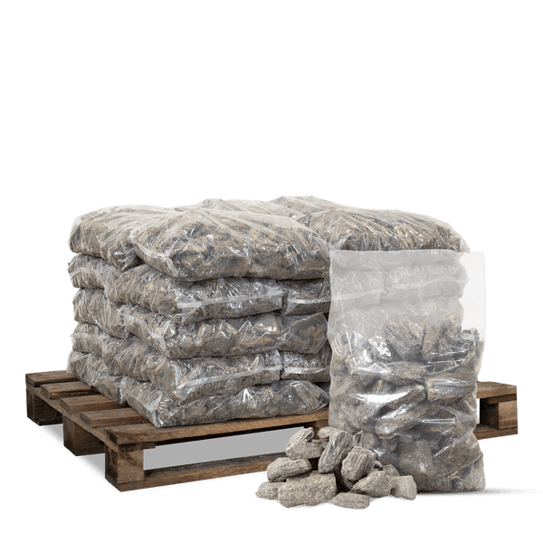 Natursteine in Säcken auf einer Holzpalette gestapelt mit einem geöffneten Sack und losen Steinen.