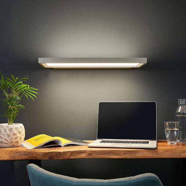 Moderne rechteckige LED-Wandleuchte über einem Holzschreibtisch mit Laptop, Pflanze und Buch in einem organisierten Arbeitsbereich.