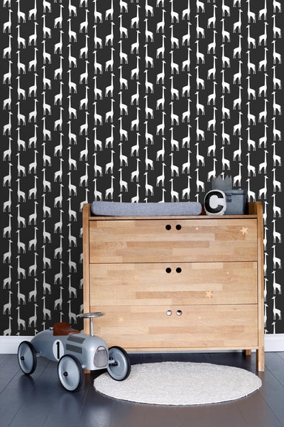 Helles Kinderzimmer mit Holzkommode, Spielzeugauto und Giraffentapete