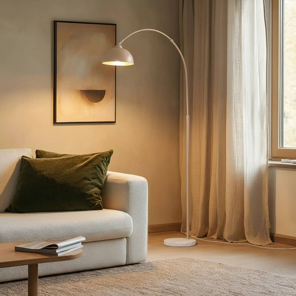 Wohnzimmer mit Bogenlampe, Sofa, Kissen und Bild
