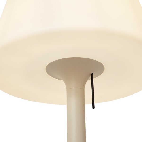 Nahaufnahme einer Lampe mit großem Schirm, zylindrischem Standfuß und einem schwarzen Zugschalter.