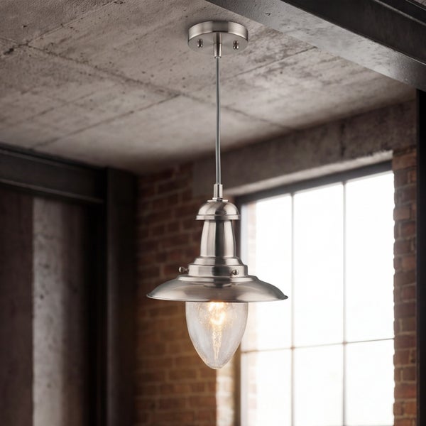 Industrielle Pendelleuchte aus Metall mit Glasschirm in einem Raum mit Backsteinwand und Sichtbetondecke.