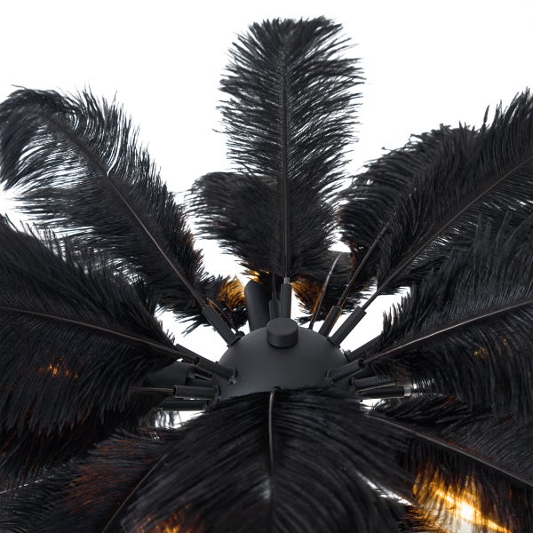 Deckenleuchte mit schwarzen Federn in Fächeroptik und warmem Lichtschein.