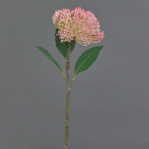 Künstliche Blume mit rosafarbenem Blütenkopf und grünen Blättern am Stiel.