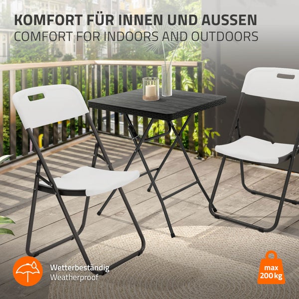 Gartenset mit Klapptisch und Klappstühlen auf einem Balkon