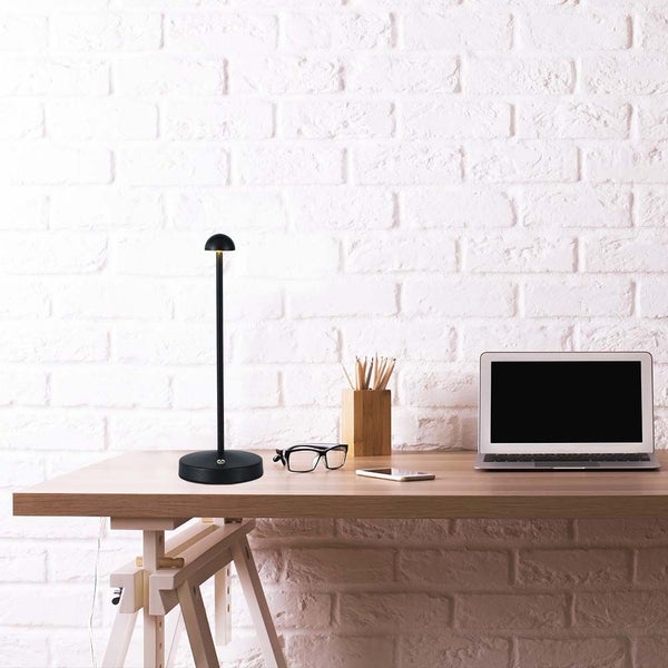 Schreibtisch mit Lampe, Laptop, Brille, Stifthalter und Mobiltelefon.