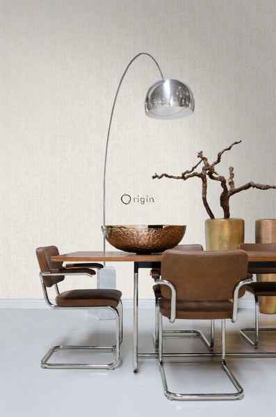 Esszimmer mit Esstisch, Stühlen, Dekoration und Stehlampe vor einer strukturierten Tapete.