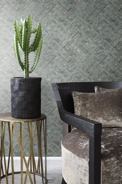 Dekorative Szene mit Zimmerpflanze im Topf, Beistelltisch und Sessel vor einer gemusterten Tapete