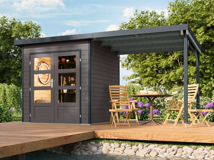 Modernes dunkelgraues Gartenhaus aus Holz mit Doppeltür, Glasfenstern und einem seitlichen Anbau mit Terrasse und Gartenmöbeln auf einem Holzdeck.
