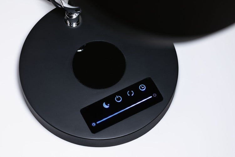 Sockel einer Schreibtischlampe mit Touch-Bedienfeld für Helligkeit, Farbtemperatur und Timer sowie integrierter induktiver Ladefläche.