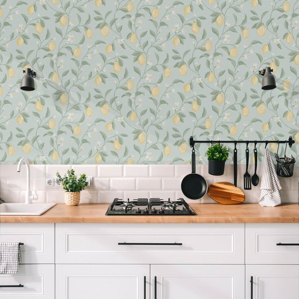 Küchenszene mit weißer Einbauküche und einer Tapete mit Zitronenmuster