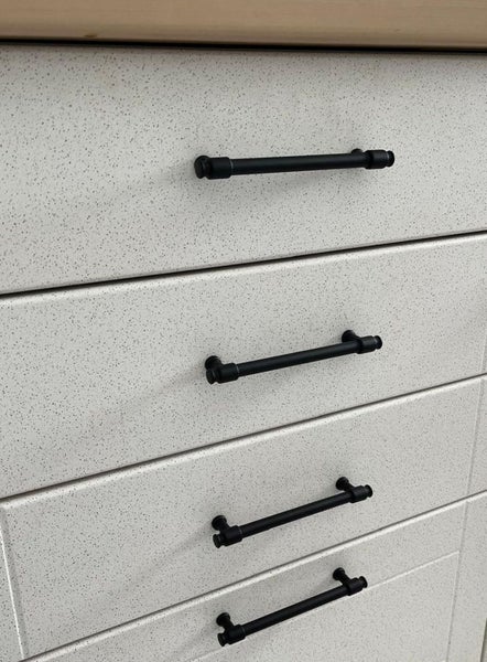 Schubladenfronten mit schwarzen Stangengriffen