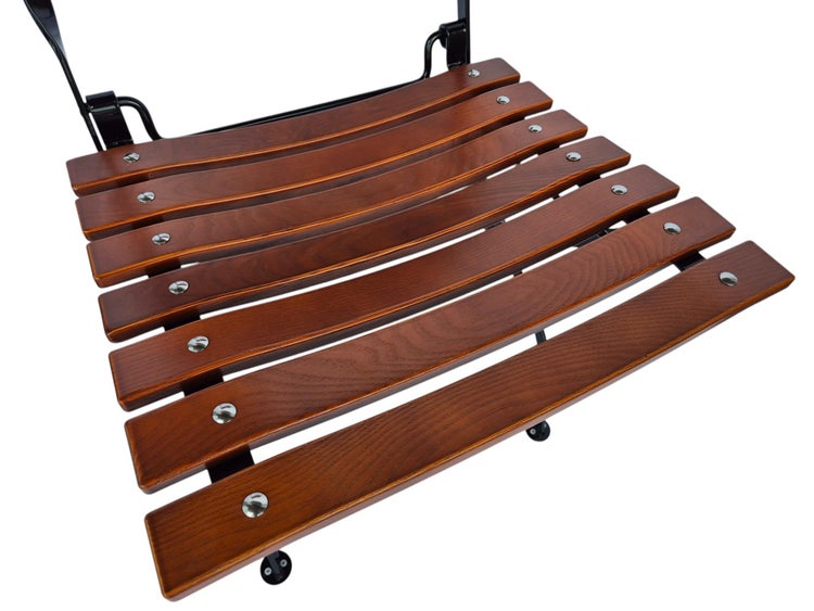 Sitzfläche eines Gartenstuhls aus gebogenen Holzlatten mit einem schwarzen Metallgestell.