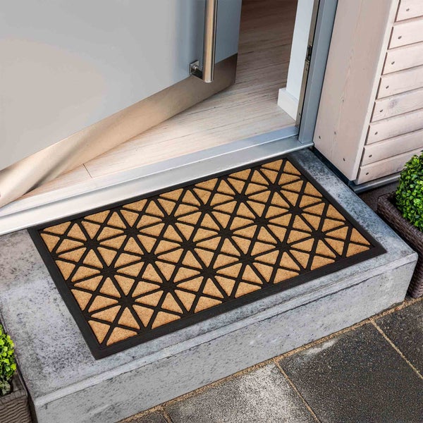 Fußmatte mit Dreiecksmuster vor einer geöffneten Tür