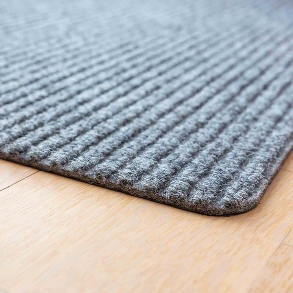 Fußmatte mit Rippenstruktur auf Holzboden