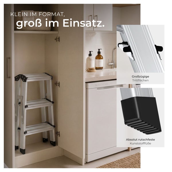 Klappbare Aluminium-Stehleiter mit drei Stufen in hellem Küchenschrank, Details der breiten Trittflächen und rutschfesten Kunststofffüße.