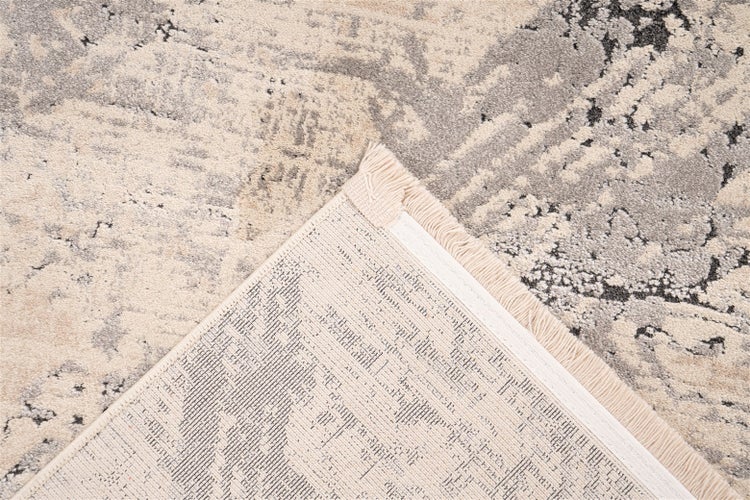 Nahaufnahme eines Teppichs im Vintage-Stil mit orientalischem Muster, umgeknickte Ecke mit Fransen und gewebter Rückseite.