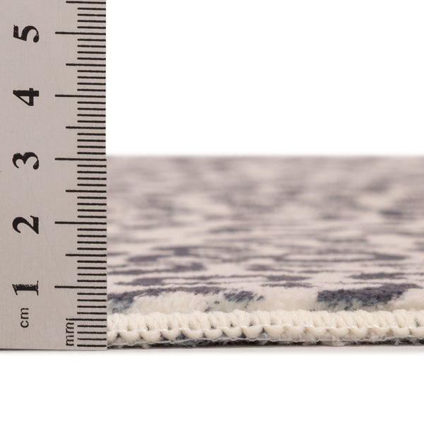 Teppich mit einer Florhöhe von circa 10 Millimeter gemessen mit einem Lineal.