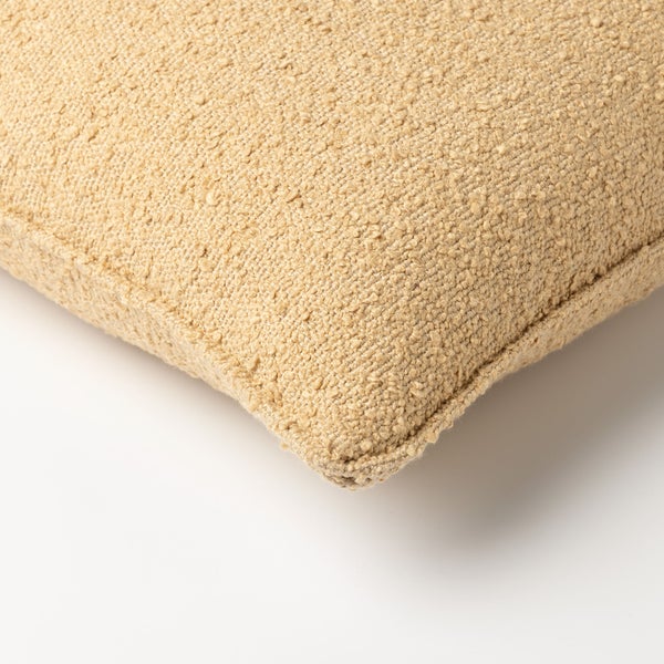 Wohnzimmer mit Sofa, Kissen, Spiegel, Beistelltisch, Teppich und Kunstwerken an der Wand.