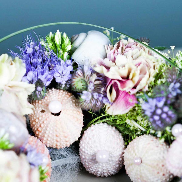 Blumenarrangement mit Blüten und Seeigeln