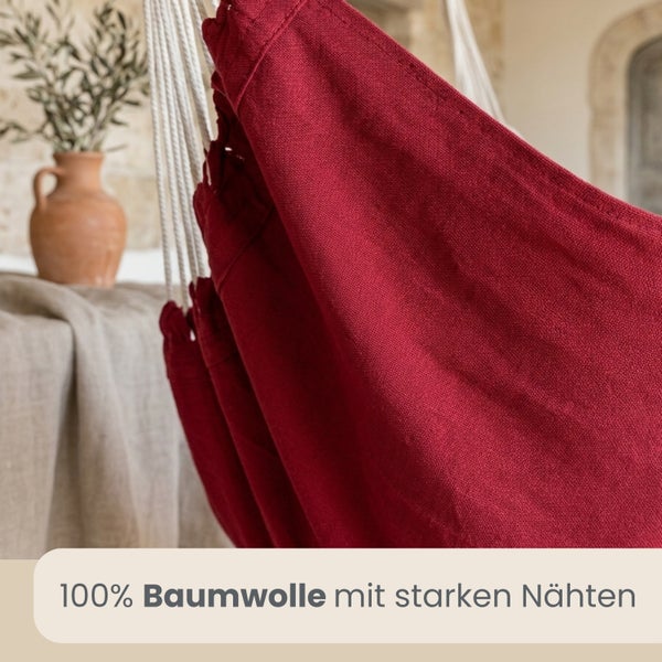 Nahaufnahme eines roten Stoffes aus 100 Prozent Baumwolle mit starken Nähten und weißen Befestigungsseilen.