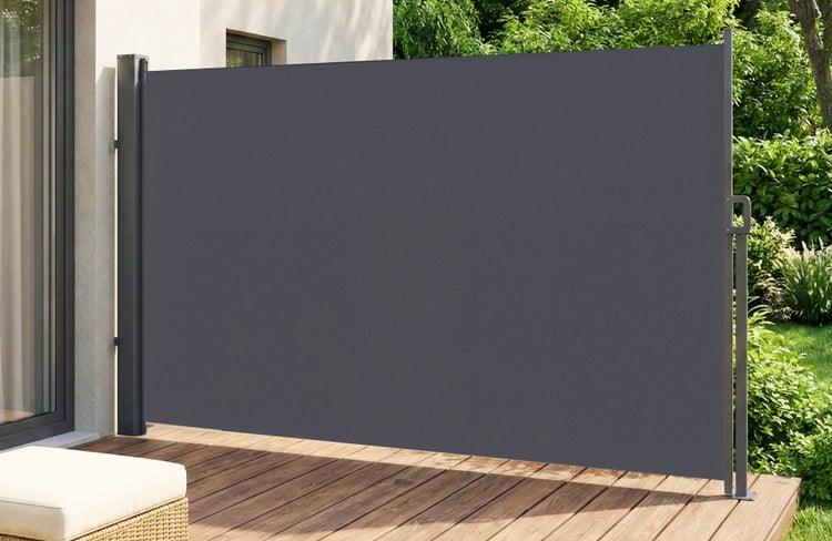 Ausziehbare Seitenmarkise auf einer Holzterrasse als Sichtschutz und Windschutz im Garten.