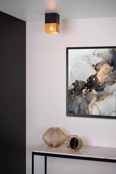 Szene mit Deckenleuchte, Bild und dekorativen Gegenständen auf einem Tisch