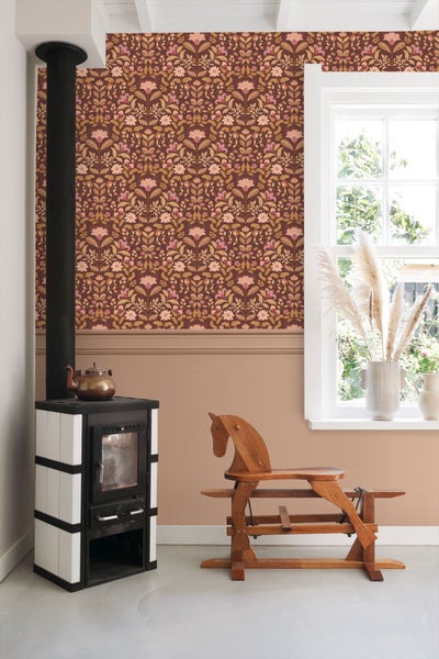 Wohnraum mit Ofen, Holzpferd und floral gemusterter Tapete