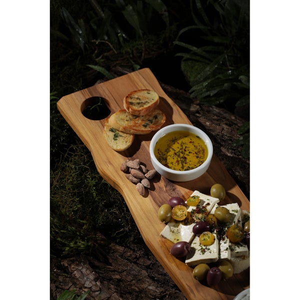 Holztablett mit Brot, Oliven, Mandeln, Feta und Öl
