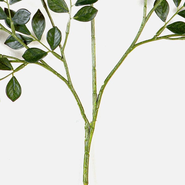 Künstlicher Zweig mit grünen Blättern zur Dekoration.