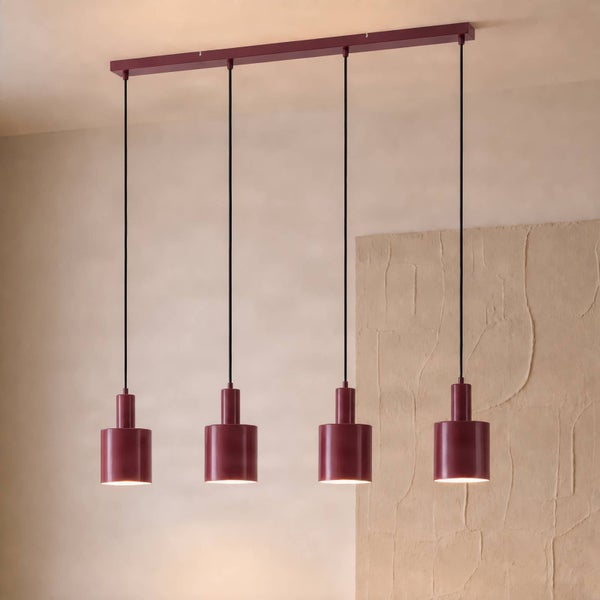 Vierflammige Pendelleuchte mit zylindrischen Schirmen über einem Holzesstisch in einem modern eingerichteten Esszimmer.