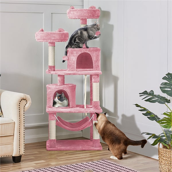 Rosa Katzenkratzbaum mit mehreren Ebenen, Höhlen und Hängematte in einem Wohnzimmer mit drei Katzen
