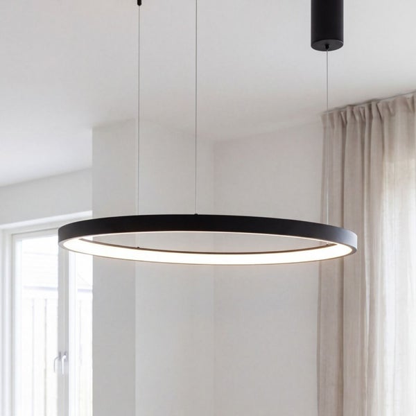 Moderne, minimalistische LED-Ringpendelleuchte in einem hellen, geräumigen Raum mit weißen Wänden und einem hellen Vorhang.