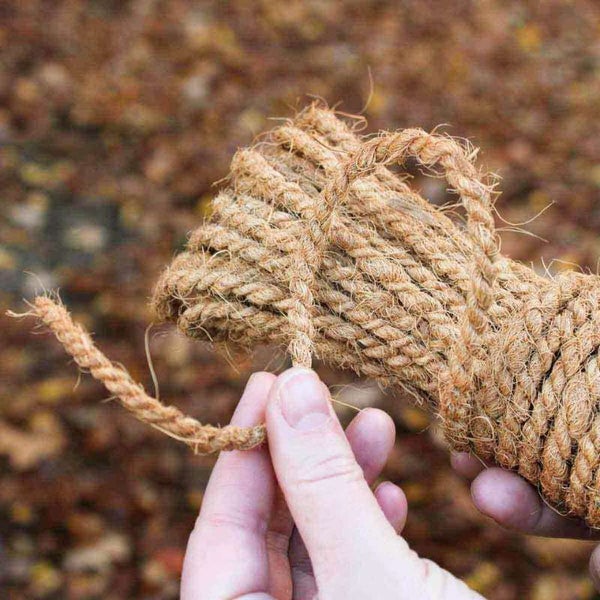 Aufgewickeltes Seil aus Naturfasern wird von einer Hand gehalten.