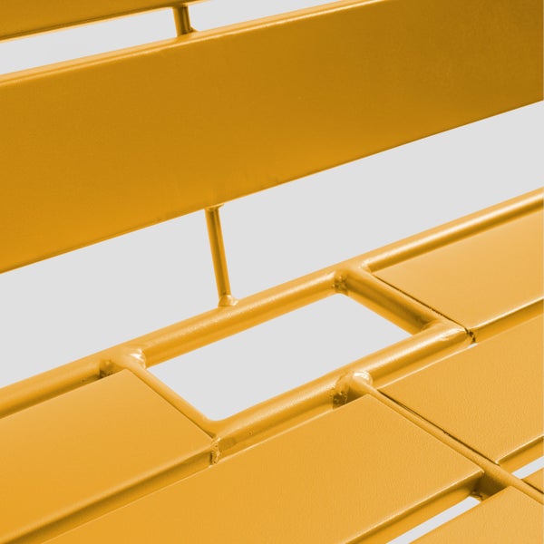 Detailansicht einer gelben Tischplatte aus Metall mit parallelen Latten und abgerundeter Kante.