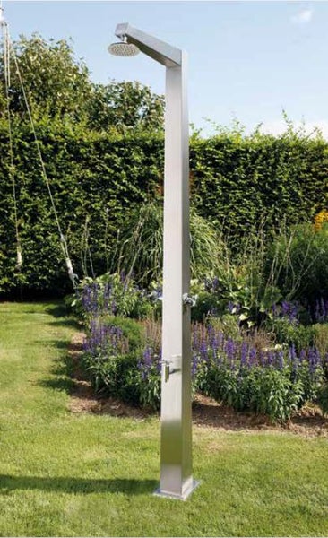 Moderne Gartendusche aus Edelstahl mit Duschkopf und Armatur in einem gepflegten Garten mit Rasen und Pflanzen.