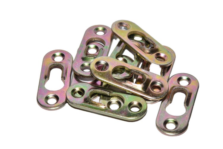Ein Haufen flacher Schlüssellochaufhänger aus Metall für die Wandmontage von Spiegeln und Bilderrahmen.