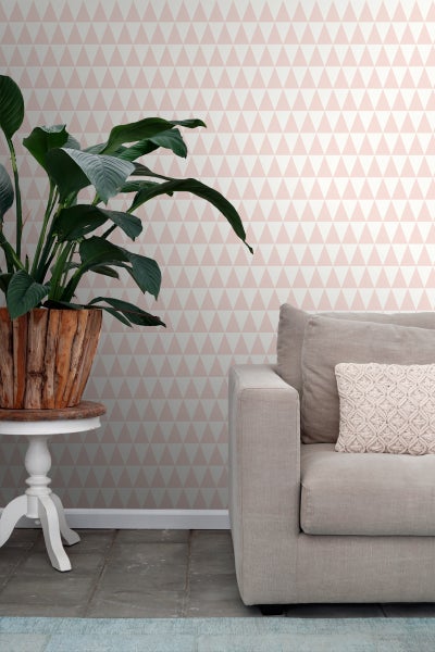 Wohnzimmer mit dreieckiger Tapete, Zimmerpflanze und Sofa.