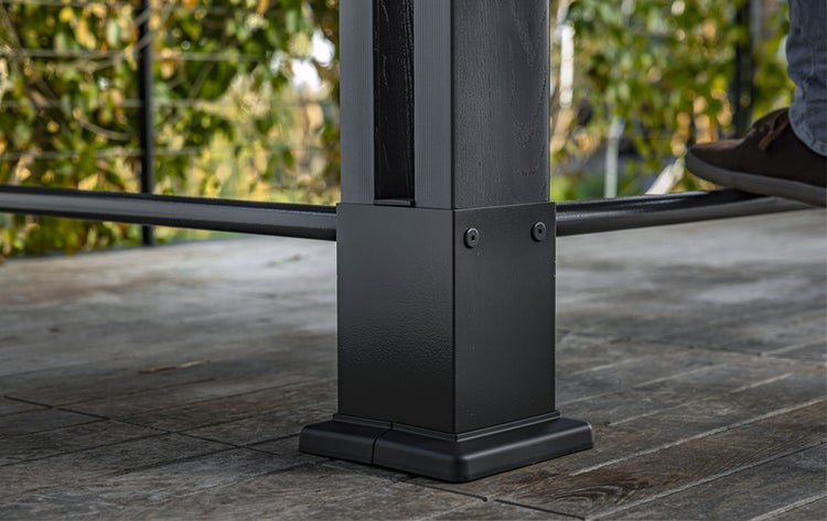 Detailansicht eines schwarzen Terrassenpfostens aus Metall und Holz auf einem Holzboden.