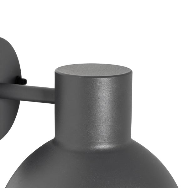 Detailansicht einer Wandleuchte für den Außenbereich aus Metall in Anthrazit mit matter Oberfläche, zylindrischer Leuchtenkopf mit Haltearm.