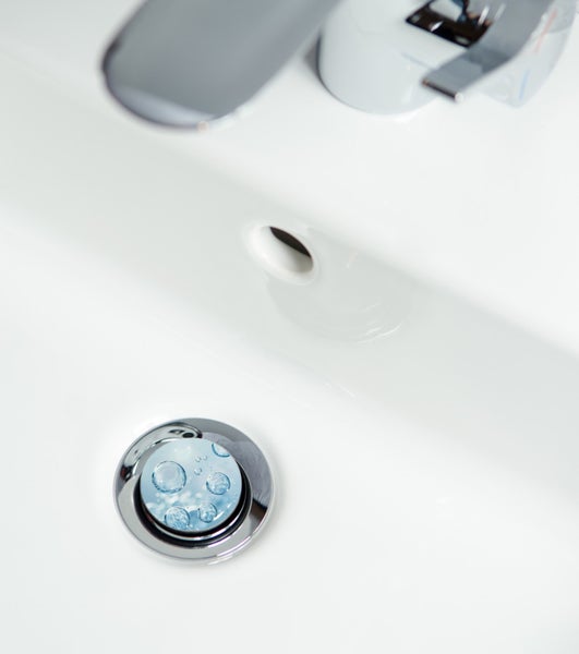 Detailansicht eines Waschbeckens mit Wasserhahn und Abfluss