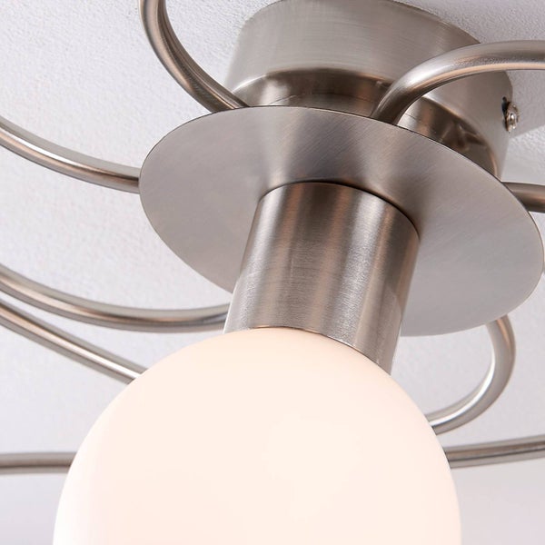 Deckenleuchte aus gebürstetem Metall mit weißem kugelförmigem Glas und geschwungenen Armen.