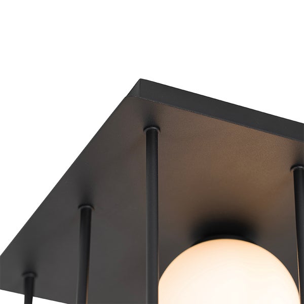 Detail einer Deckenleuchte mit Metallrahmen und runder Glühbirne