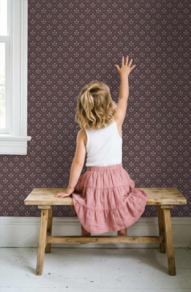 Tapete mit floralem Vintage-Blumenmuster in einem Zimmer, Kind sitzt auf einer rustikalen Holzbank vor der Wand.