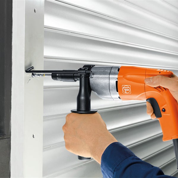 Eine Person bohrt mit einer orangefarbenen Fein Bohrmaschine in einen Rollladen