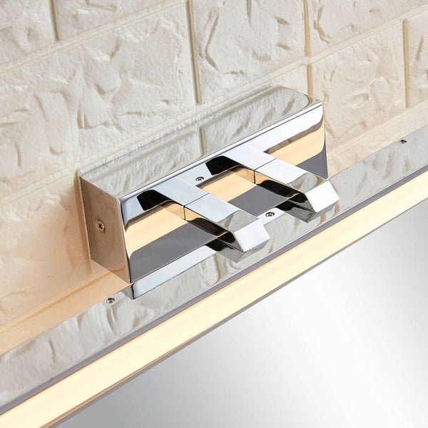 Moderne LED-Badspiegelleuchte aus Chrom, montiert auf einem Spiegel vor einer strukturierten Wand.