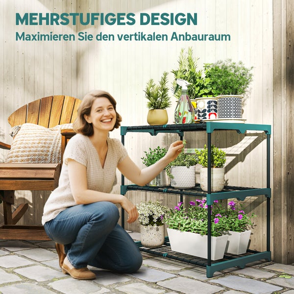 Frau neben einem dreistufigen Pflanzenregal aus Kunststoff für vertikalen Anbau mit verschiedenen Topfpflanzen vor einer Holzwand.