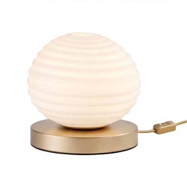 Kugelförmige Tischleuchte mit weißem gerilltem Glasschirm und rundem Metallfuß in Messingoptik inklusive Schnurschalter.