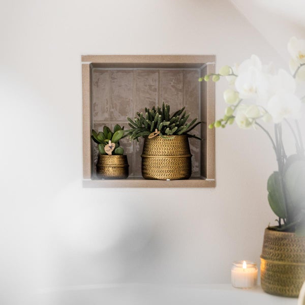 Wandnische im Badezimmer mit zwei Sukkulenten in strukturierten Töpfen auf gefliestem Hintergrund, helle Atmosphäre.