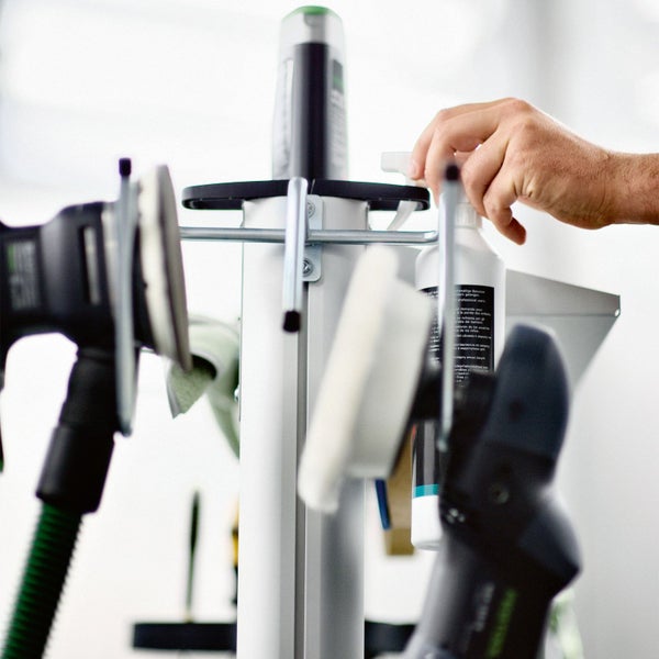 Schleifmittel und Reiniger auf einem Werkzeugwagen mit Hand.